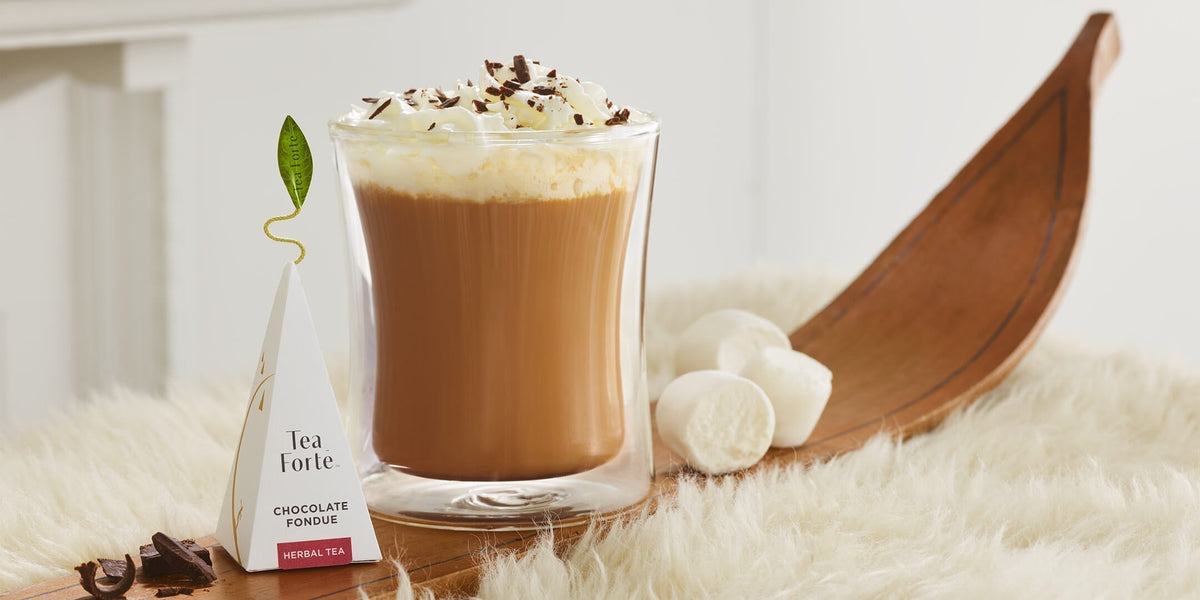 Chocolate Fondue pyrmid infuser with brewed tea in a POOM glass on a wooden antique ski