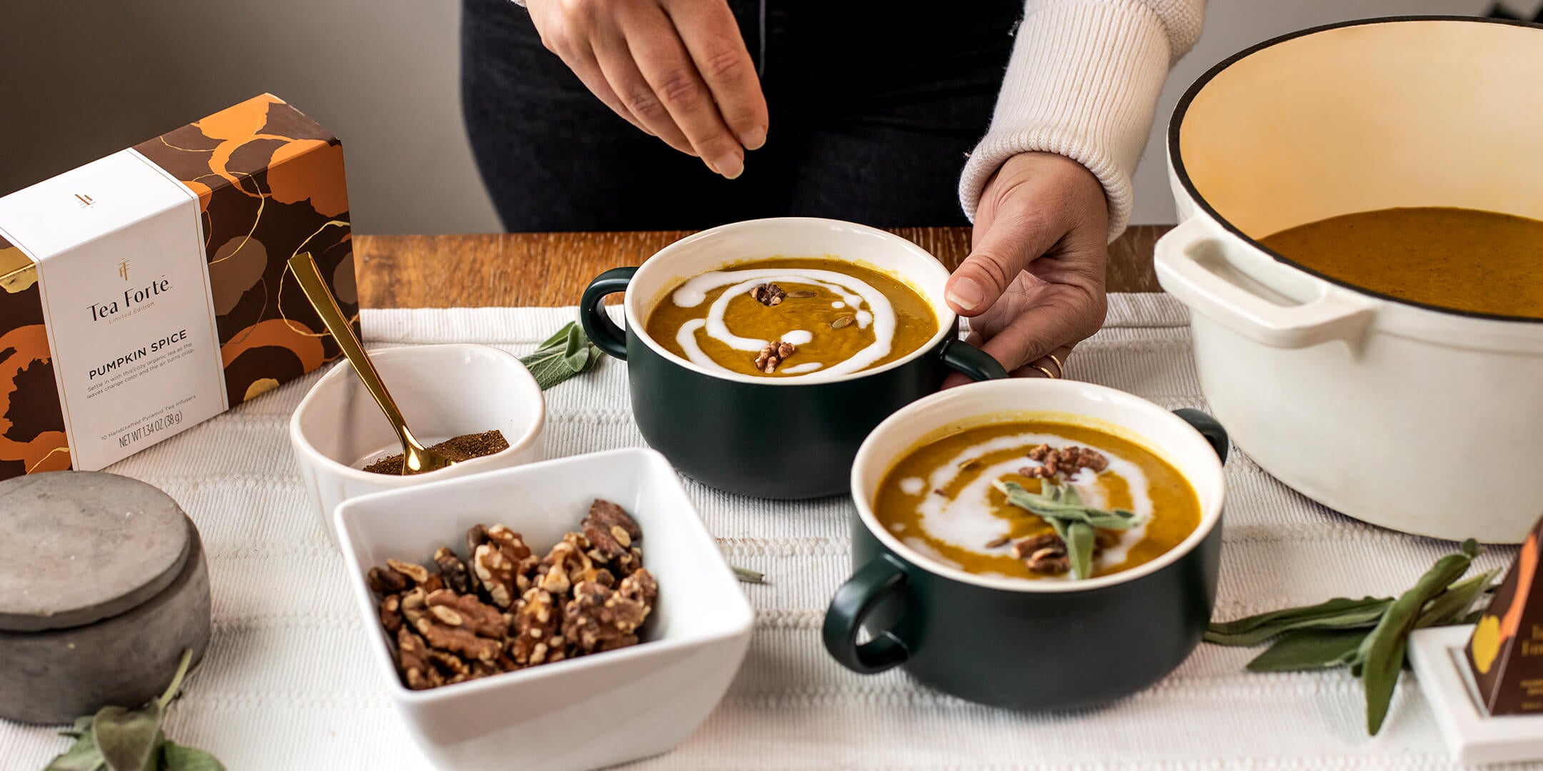 Topping Turmeric Pumpkin Spice Soup with pumpkin seeds in a kitchen