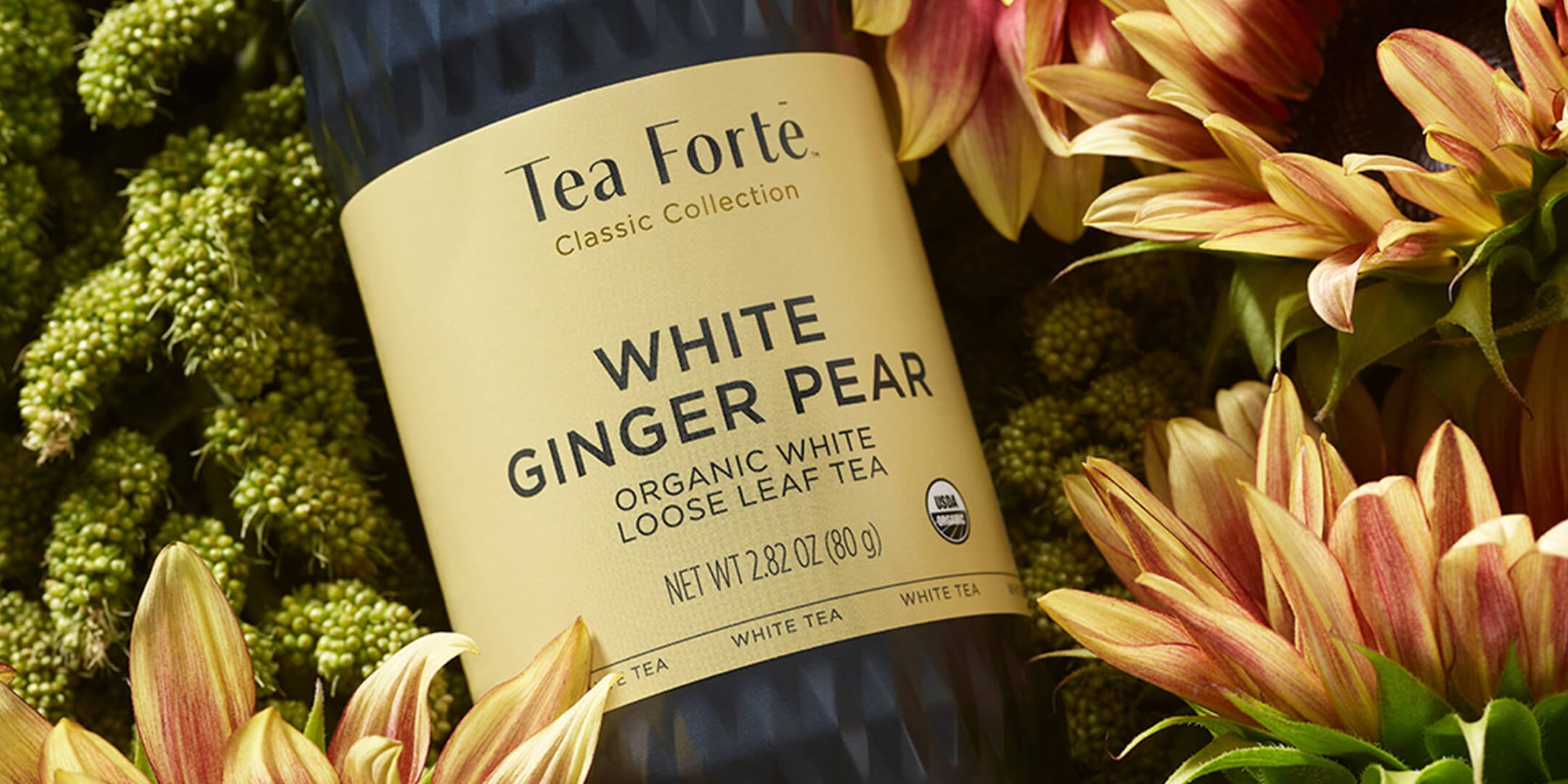 White Ginger Pear loose tea canister laying on a bed of flowers