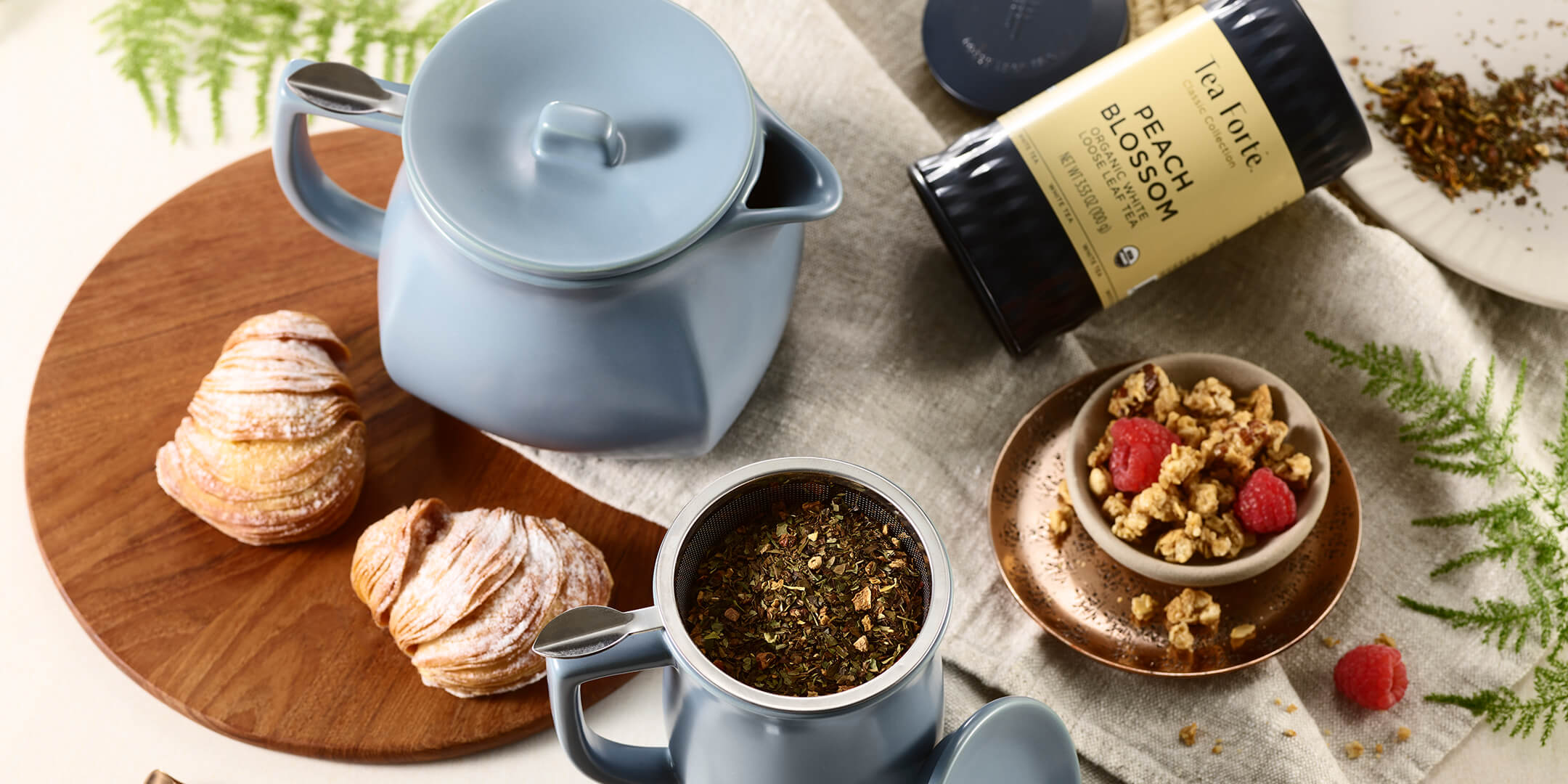 Fiore Teapot and steeping cup with loose tea on breakfast table