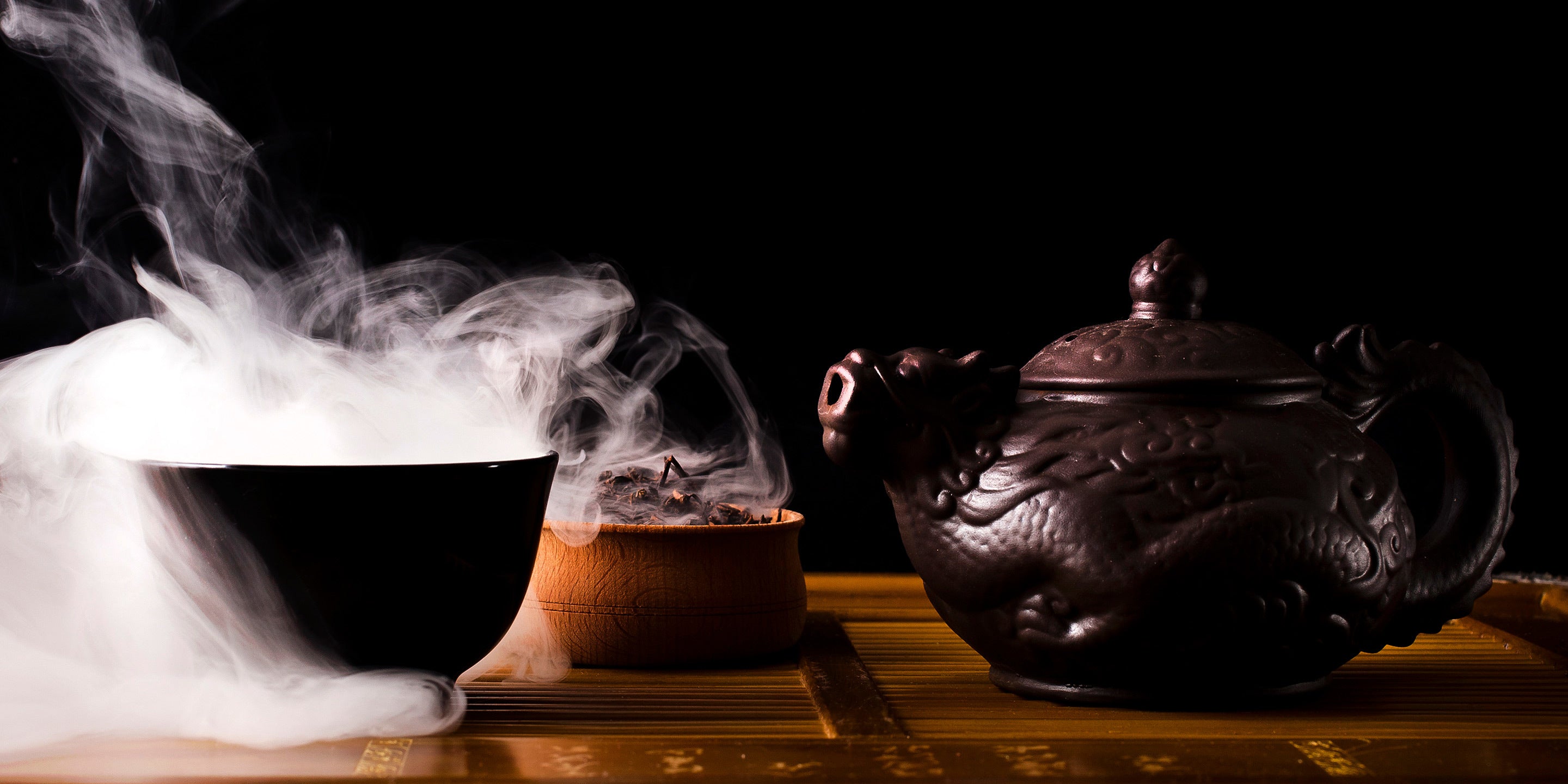 Smoking tea in a cup with teapot