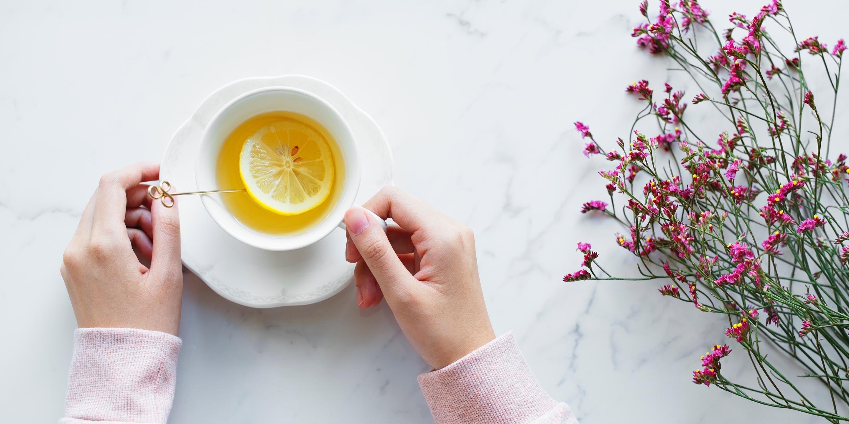 Holding a cup of tea with lemon slice