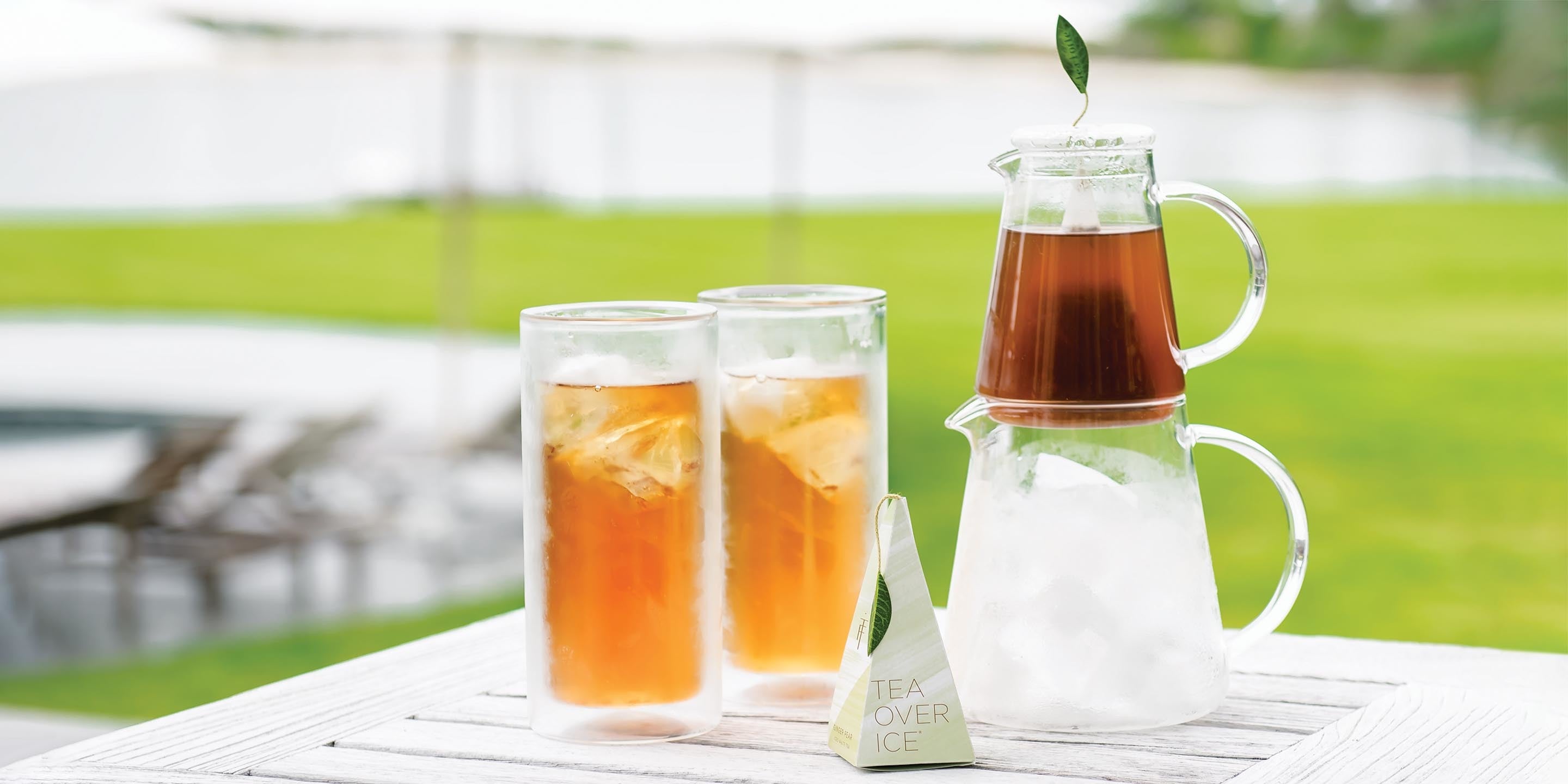 Tea Over Ice Pitcher Set and 2 iced tea glasses, on table outside.