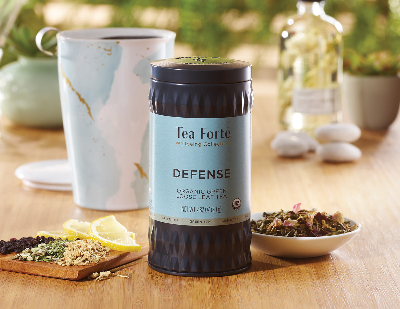 Defense Loose Tea Canister of 35-50 servings on a table with a Wellbeing KATI Cup in the background