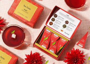 Ruby Mini Petites on a table with red flowers and cups of tea
