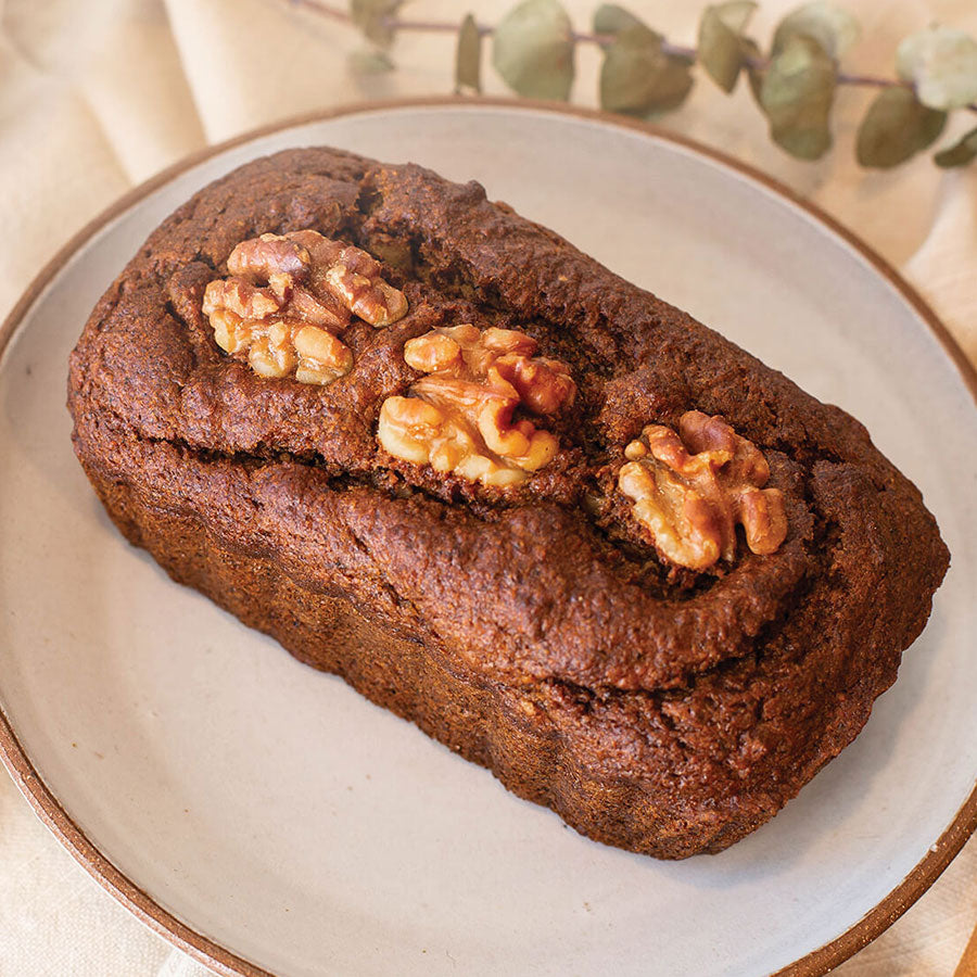 Pumpkin Spice Tea Loaf on a plate with walnuts on top