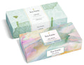 Two Tea Forté boxes: one mint green with lotus leaf design, one watercolor multicolor with wellbeing label.