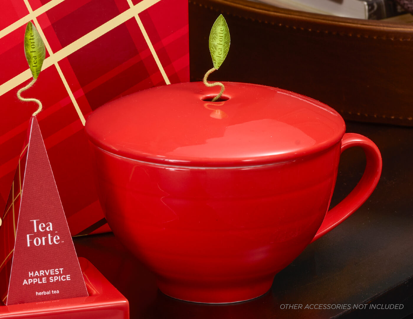 Ruby Red Café Cup with cover closed next to other Warming Joy items