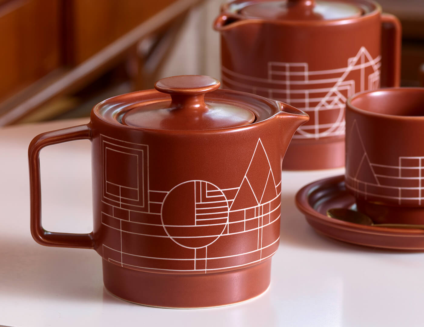 Terra stoneware teapot and infuser on a table with other Terra accesories