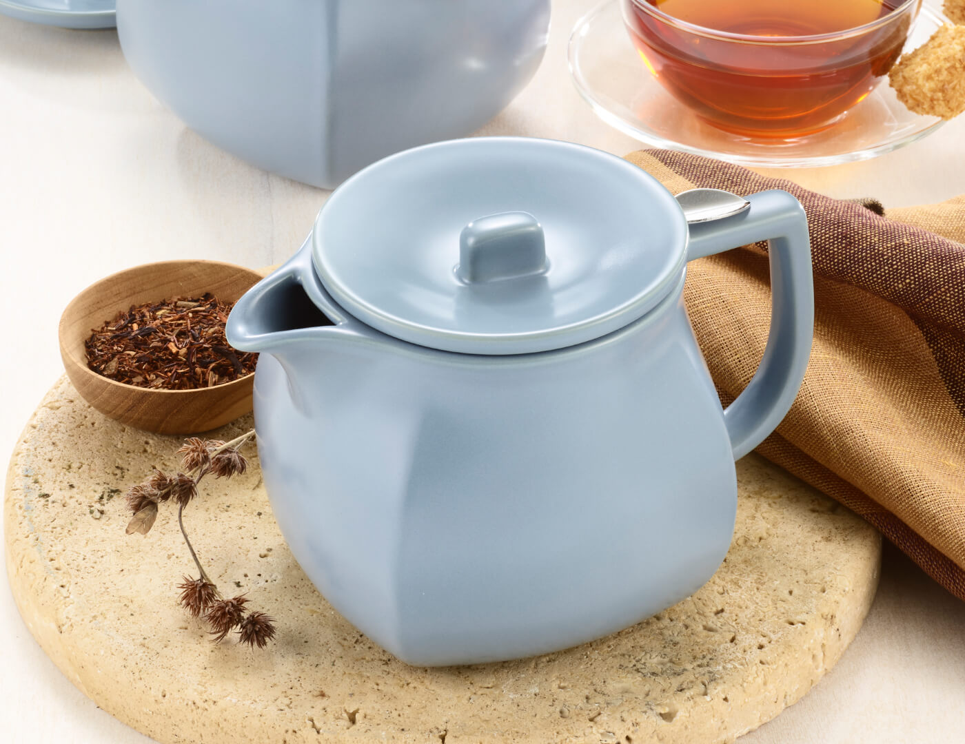 Fiore Stone Blue Teapot with lid on table with loose tea and teacup