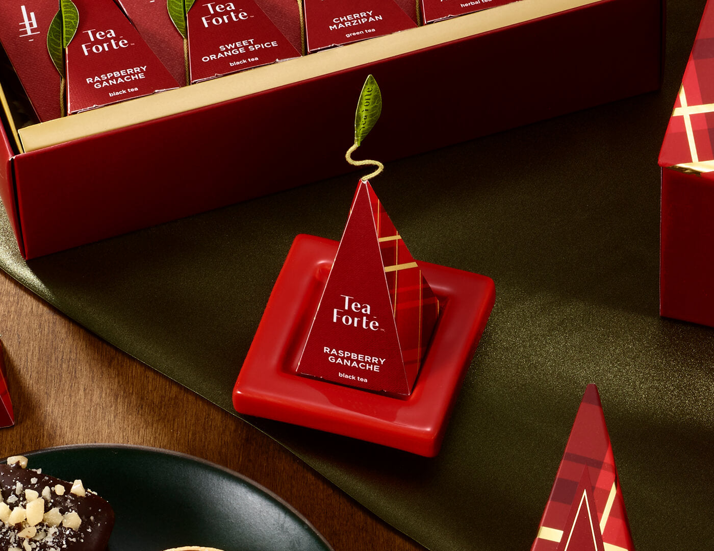 Ruby Red Tea Tray with infuser perched on top resting on festive table with a open box in background
