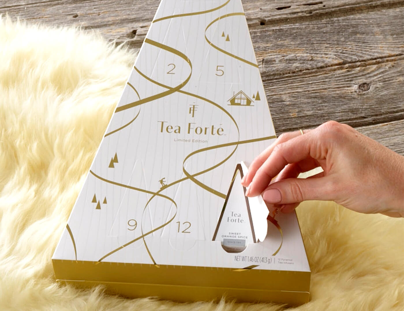 Opening the door to reveal a pyramid infuser in the 12 Days of Cozy Teas Advent Calendar