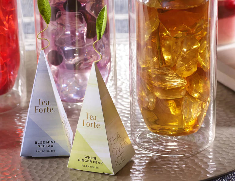 Infuser of white ginger pear next to a glass of iced tea
