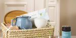 Gift basket of wellness tea items, blue teapot, tray, box of tea and white teacup.