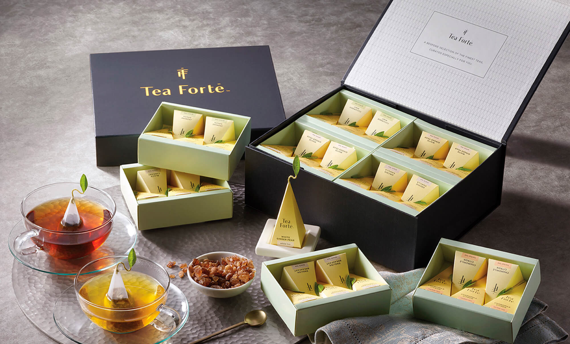 Tea Forté SELECT, open box on a table with tea and amber sugar and infusers