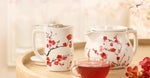 Fiore Sakura Teaware collection on a table with a glass cup of tea
