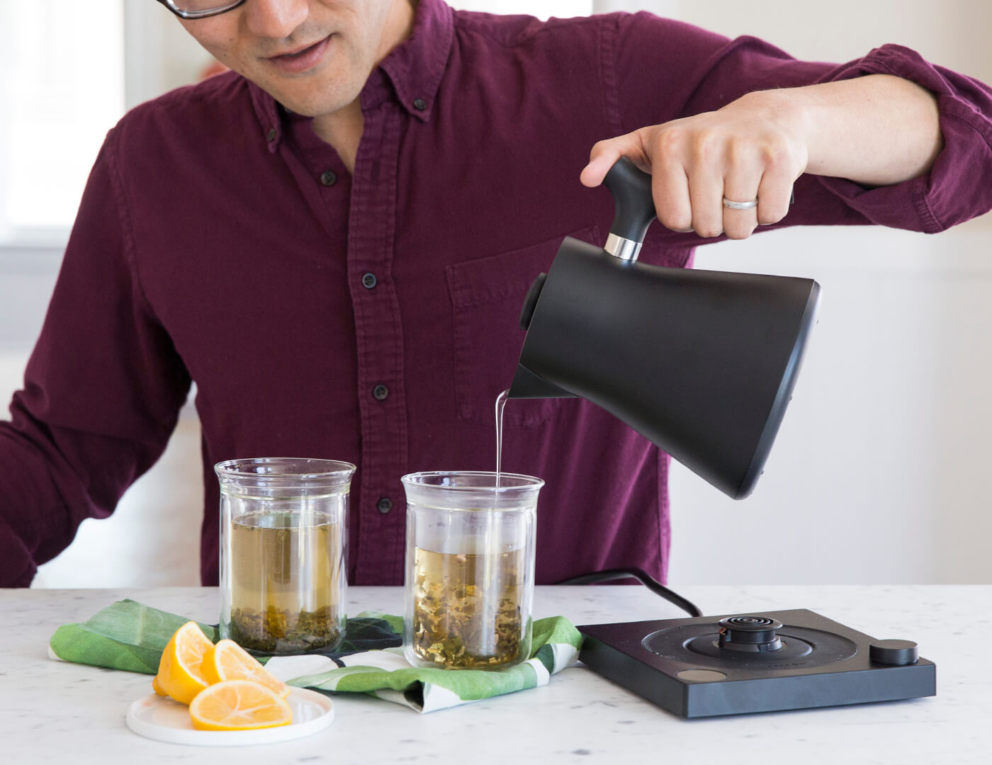 Pouring hot water into tea glasses from the Black Corvo Kettle EKG