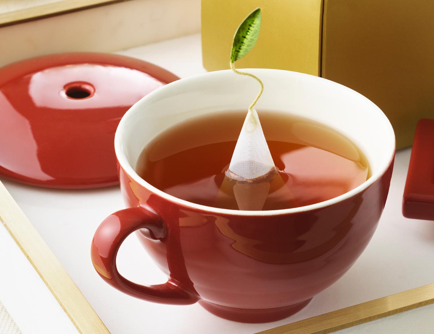 Red Café Cup with lid off, tea infuser steeping inside.