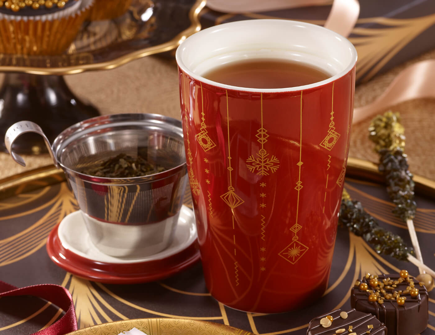 KATI Steeping Cup Warming Joy with metal infuser basket and lid removed, on a holiday styled table