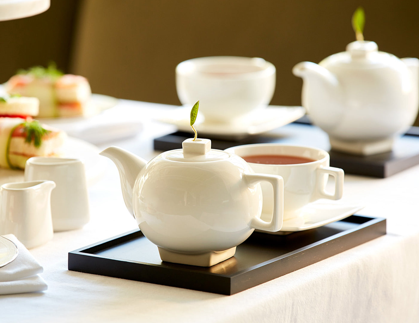 Solstice teapot with tea cup on a black tray on a dining room table