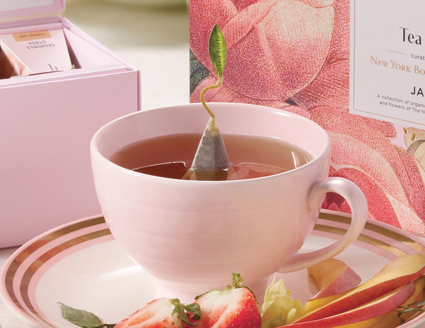 Café Cup porcelain tea cup in pink on table with fruit.