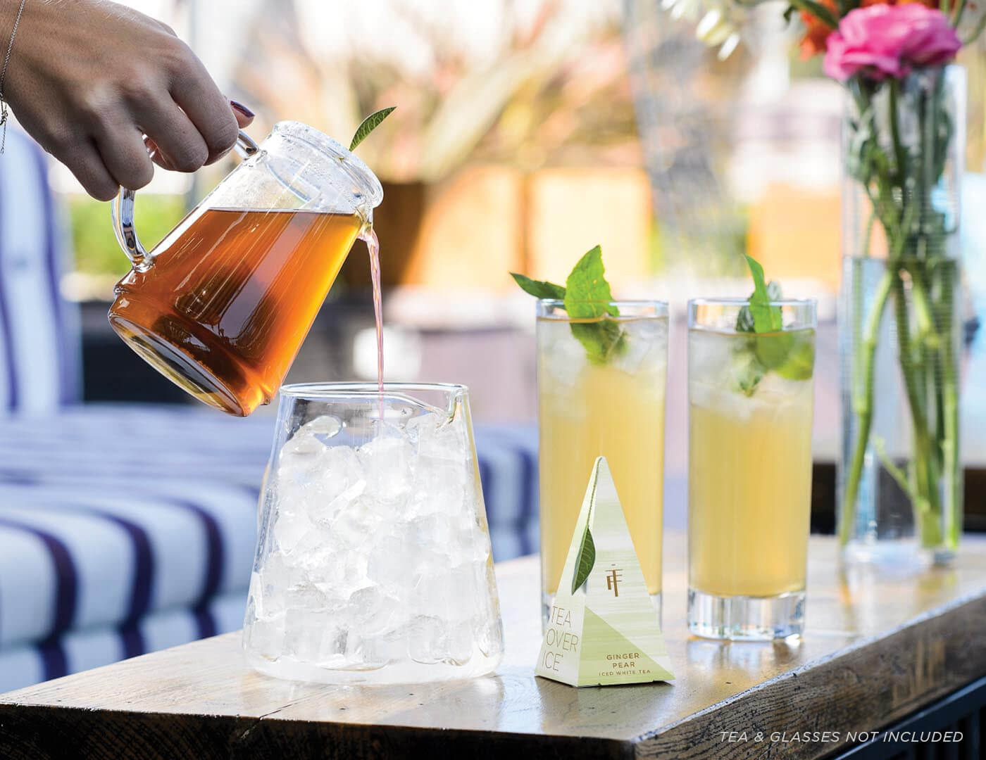 Image of Tea Over Iced Pitcher Set Pouring next to Pyramid and Glasses